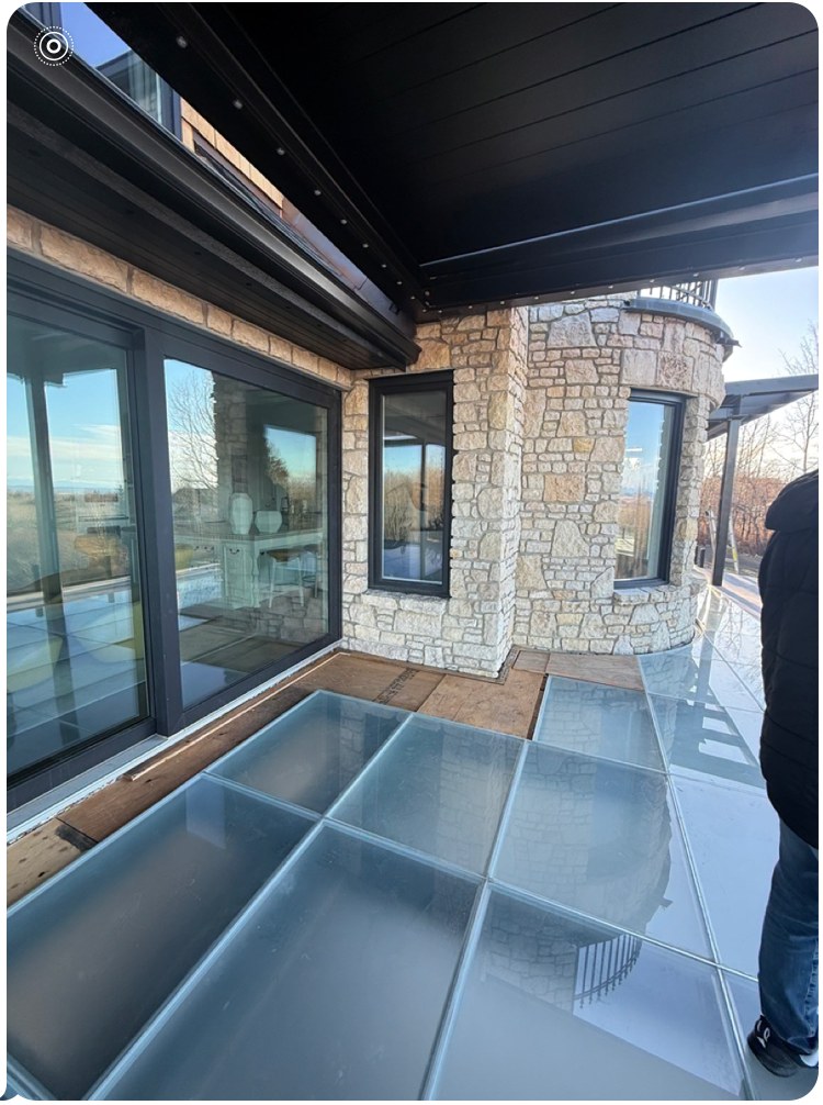 Glass floor patio beside stone exterior
